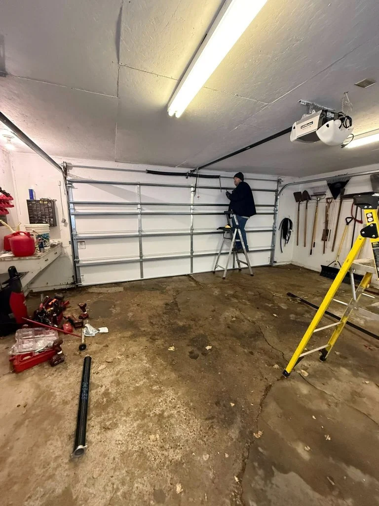 Pronto technician performing spring and cable service on a residential garage door
