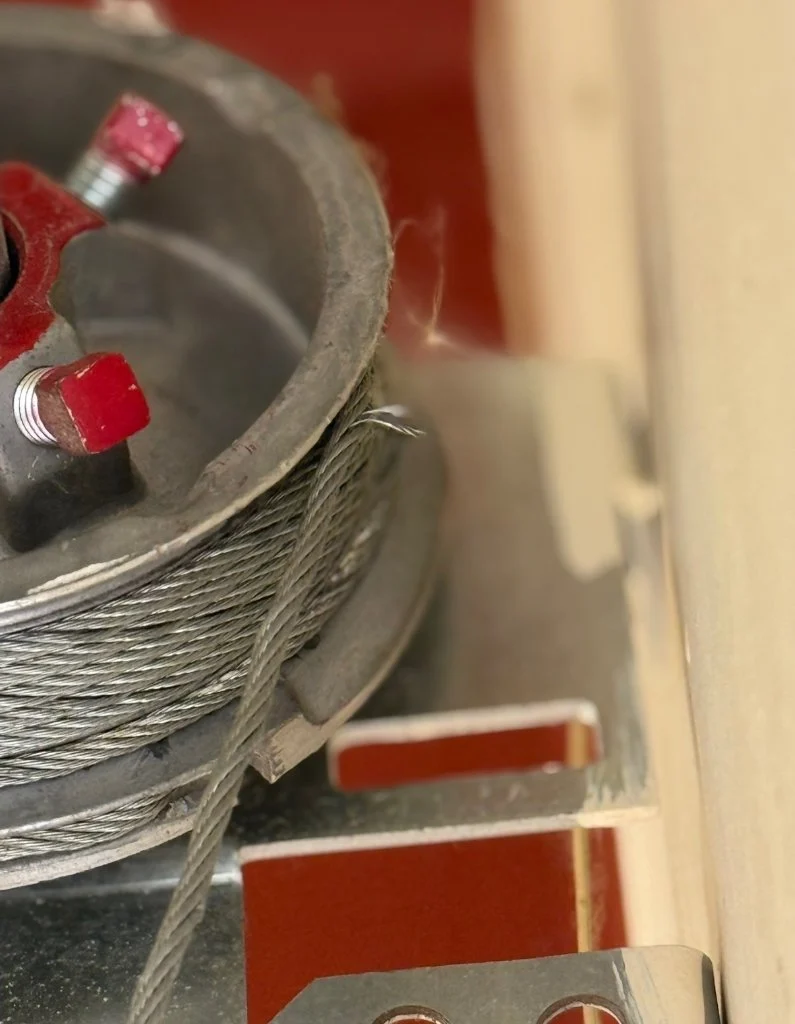 Garage door torsion spring and cable pulley hardware on a residential door